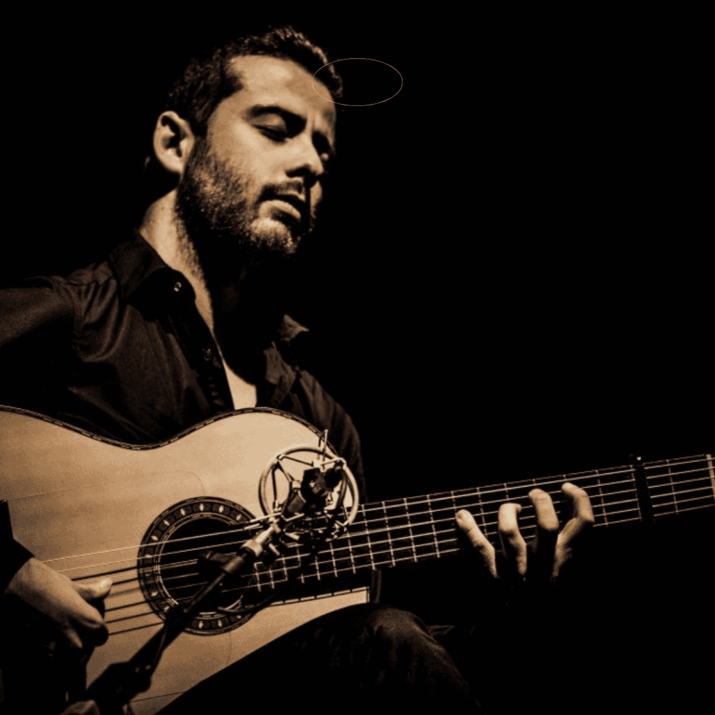 Guitarrista Alejandro Mendoza tocando en escena en concierto en vivo.