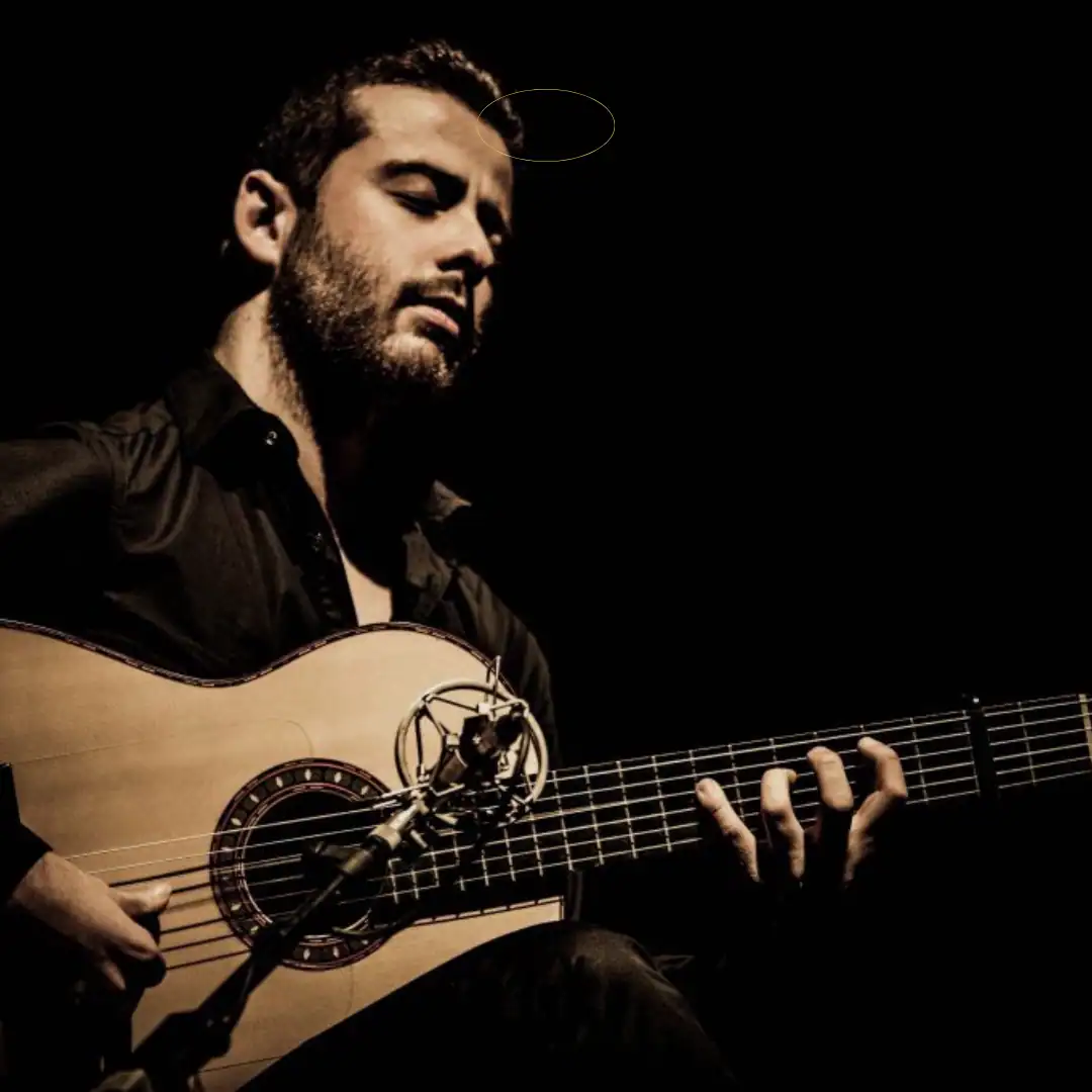 Guitarrista Alejandro Mendoza tocando en escena en concierto en vivo.